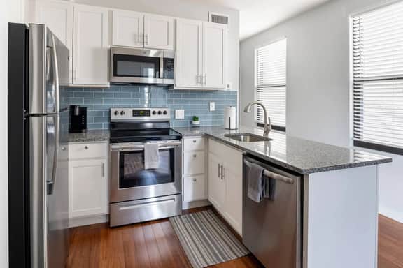 Fully equipped kitchen with stainless steel appliances (microwave, dishwasher, stove, fridge)
